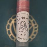Lip balm tube held outdoors